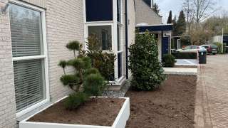 Voortuin aanleggen in Tilburg met witte planten bakken en keramische tegels 