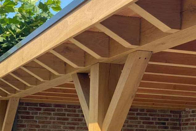 Luxe tuinoverkapping met eiken balken steekschoren sedum dak en keramische tegel vloer